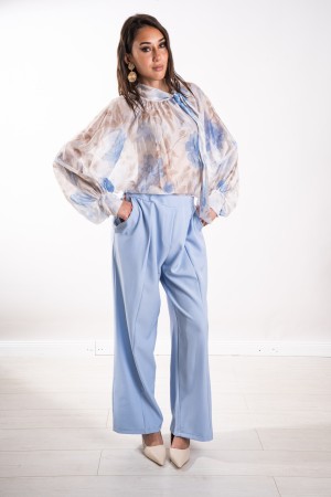 chaqueta y pantalones coordinados de Aurora de Tailleur Aurora con modelo de broche de flores sobre chaqueta y pantalones de aur